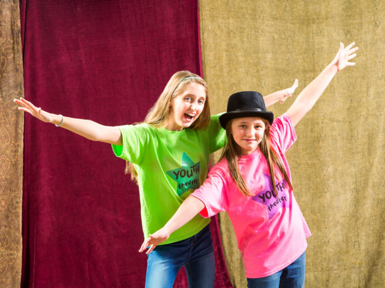 Two girls doing jazz hands